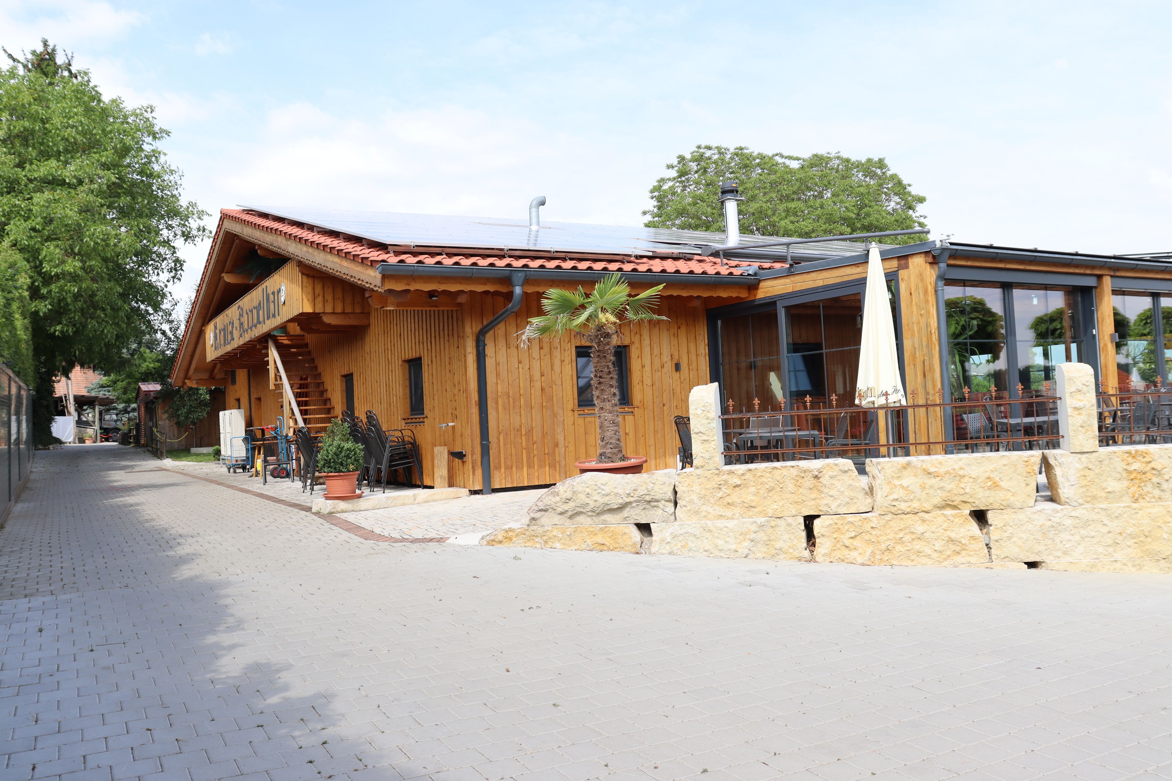 A wooden building with a sloped roof and a glass extension.