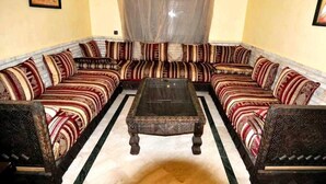 Uma sala de estar tradicional com sofá, mesa de centro e almofadas estampadas.