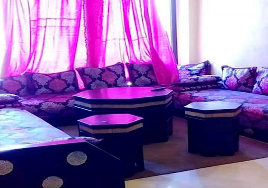 A room with a sofa set, a coffee table, and a small side table.