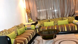 A living room with a sofa set, a coffee table, and a decorative vase. - Residence Playa del Pacha Mdiq 3407 (Mdiq)
