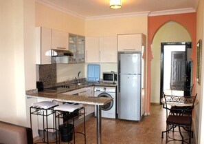 Compact kitchen with essential appliances and dining area.