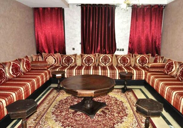 A room with a large, ornate sofa set, a central round table, and a patterned rug. - Residence Babylone Marrakech 3424 (Marrakech)