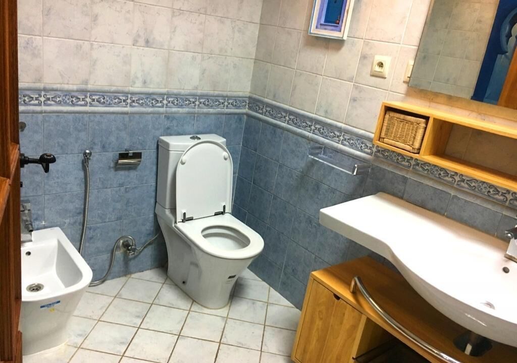 A bathroom with a toilet, bidet, and sink.