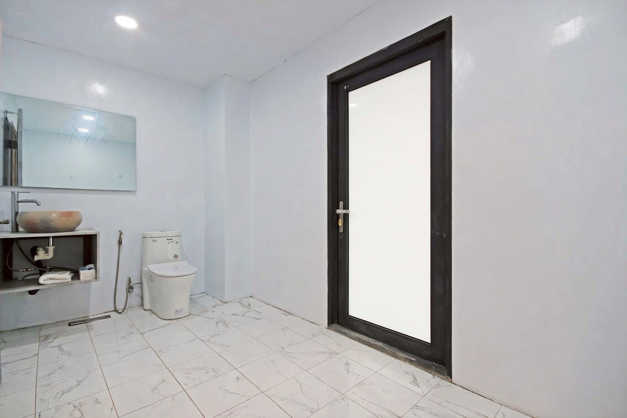 Une salle de bain avec des toilettes, un lavabo et un miroir.