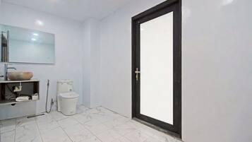 Une salle de bain avec des toilettes, un lavabo et un miroir.