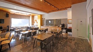 A modern dining area with wooden ceiling, marble flooring, and a kitchen in the background. - House16 (Lyudao)