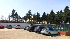 Un parking où plusieurs voitures sont garées en rangées.