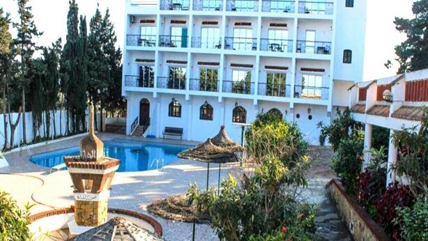 Un hôtel doté d’une piscine, d’un espace extérieur aménagé et d’un jardin.