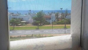 A room with a view through a window with a metal screen. - Residence Java Rasmile 2899 (Mdiq)