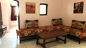 Una sala de estar con un juego de sofá, una mesa de centro y dos cuadros en la pared.