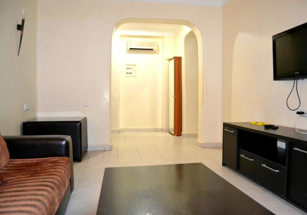 Une chambre d’hôtel comprenant un lit, un petit canapé, une télévision, un bureau et une armoire.