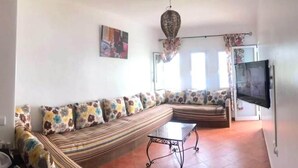 A living room with a sofa set, a TV, and a decorative ceiling light. - Residence Java Rasmile 2831 (Mdiq)