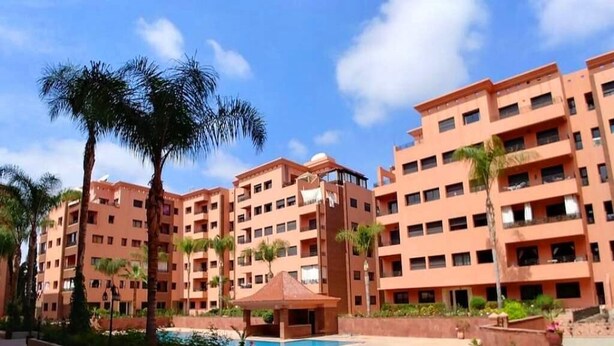 A multi-story hotel with a central courtyard, palm trees, and a swimming pool. - ����������������������������������������������������������������������������������������������������������������������������������������������������������������������������������������� (Marrakech)