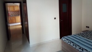 A bedroom with a bed, a door, and a view into another room. - Atlantic Ocean Residence 3041 (Asilah)