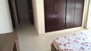 A bedroom with a bed, a wardrobe, and a door leading to another room. - Atlantic Ocean Residence 3047 (Asilah)