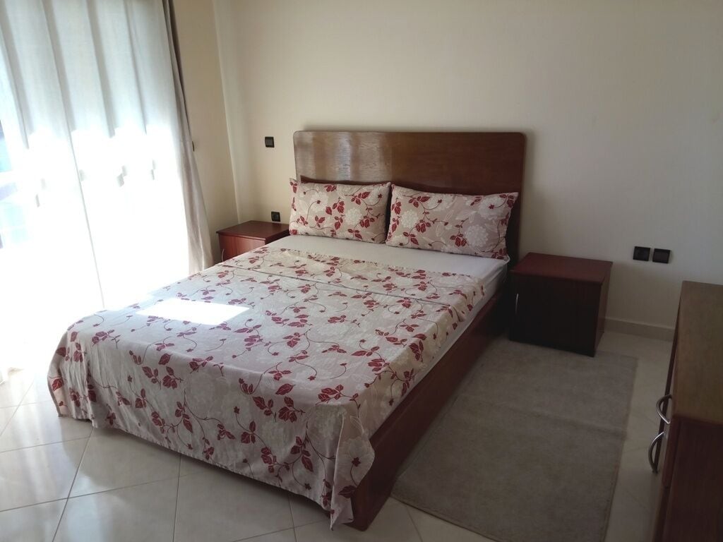 Une chambre à coucher avec un lit, des tables de chevet et une armoire.