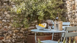A table with a bowl of fruit, two glasses, and a bottle. - The Old Dairy, Great Bircham, Norfolk (Bircham)