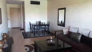 A living room with a sofa, coffee table, and dining table with chairs. - Residence Marrakech Prestigia Opal 2999 (Marrakech)