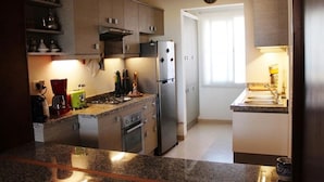 Eine moderne Küche mit Granit-Arbeitsplatten, Edelstahlgeräten und Holzschränken.