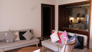 Ein Wohnzimmer mit einer Couch, zwei Sesseln und einem Couchtisch.