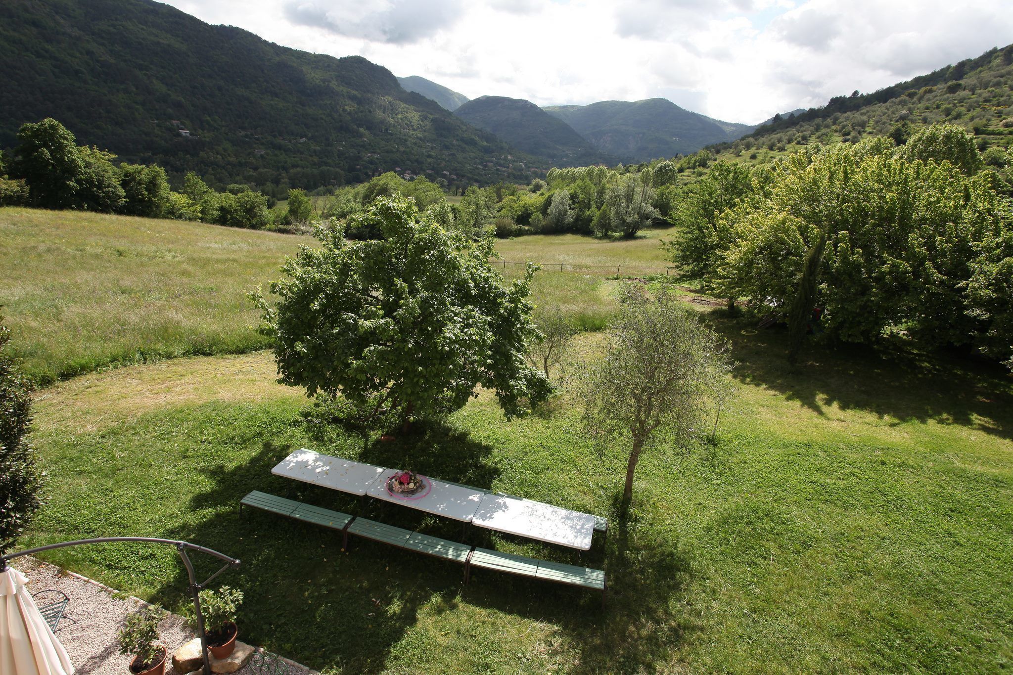 Ein Picknicktisch in einer grünen Wiese mit Bergen im Hintergrund.
