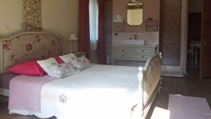 A bedroom with a bed, a dresser, a mirror, and a hanging light fixture. - La Chapelle Saint Gervais (Sospel)