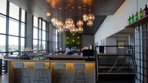 A modern bar area with a long counter, multiple stools, and hanging spherical light fixtures. - Dall'Onder Ski Hotel (Garibaldi)