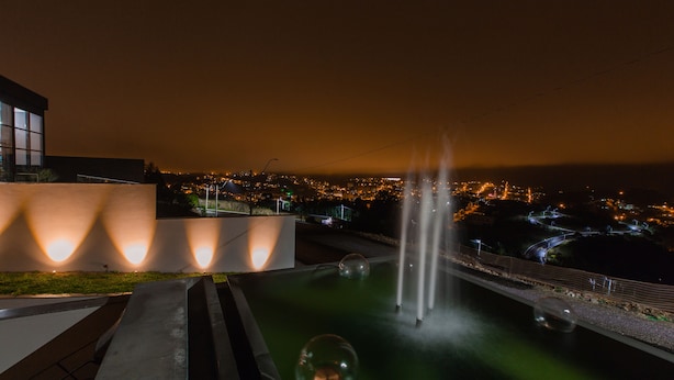 A nighttime view of a water feature with spherical objects and a bridge. - Dall'Onder Ski Hotel (Garibaldi)