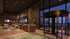 A modern hotel lobby with a reception desk, seating area, and a revolving door. - Dall'Onder Ski Hotel (Garibaldi)