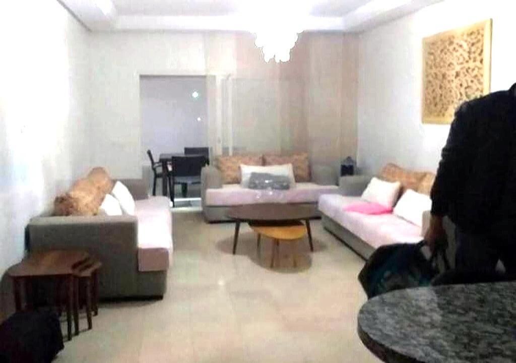 Un salon comprenant un ensemble de canapés, une table basse et un coin repas avec des chaises.