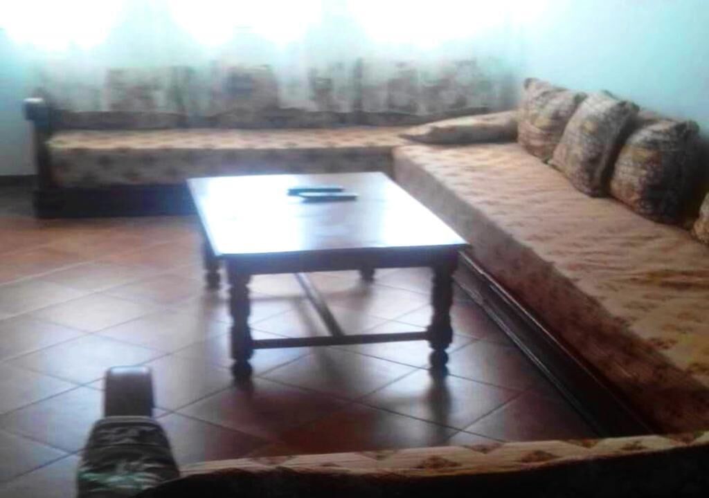 A living room with a sofa, a coffee table, and a patterned rug.