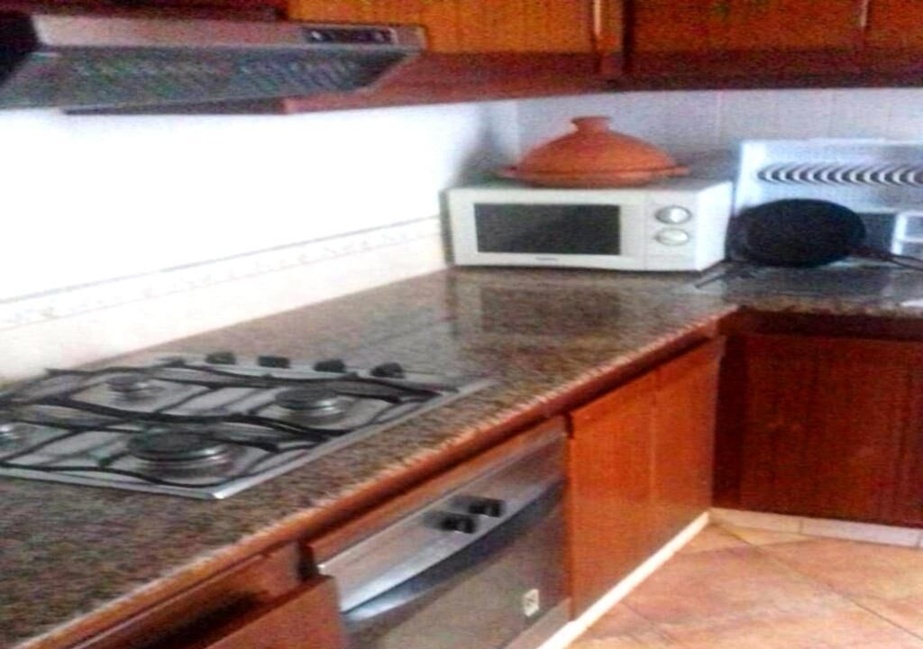 A kitchen with a gas stove, a microwave, and a stove top oven.