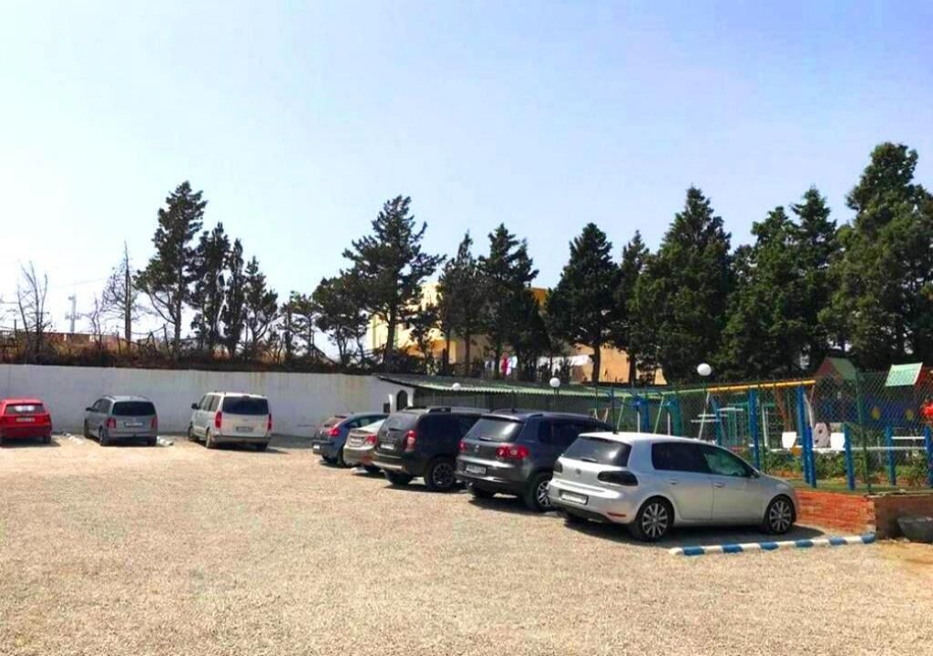 A parking lot with several cars parked in rows.