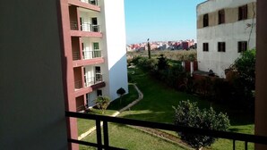 A view from a balcony overlooking a courtyard with buildings in the background. - Atlantic Ocean Residence 3043 (Asilah)