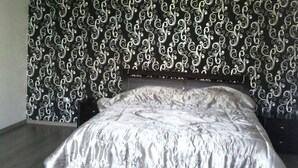 A bedroom with a bed, a headboard, and a patterned wallpaper. - Residence Marina Agadir 2952 (Agadir)