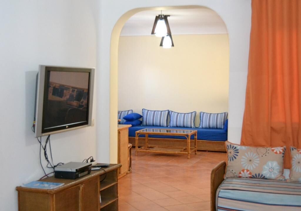 Ein Wohnzimmer mit Fernseher, Sofa und Couchtisch.