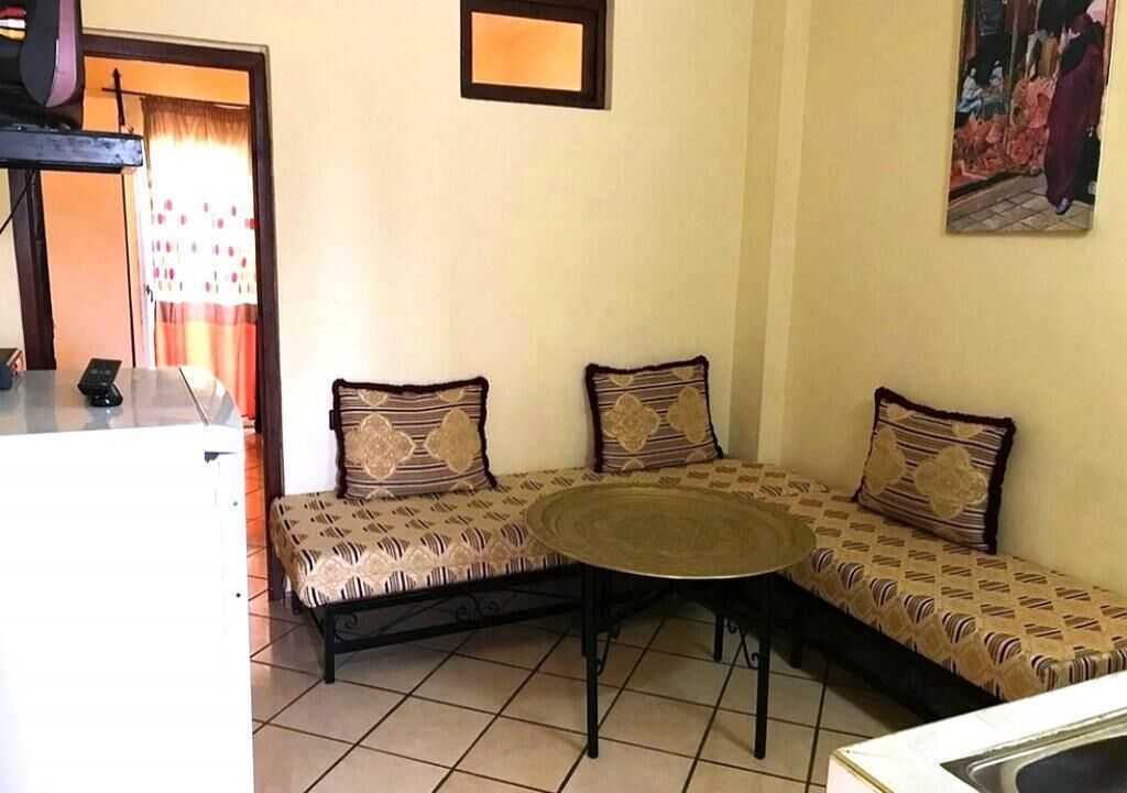 A corner seating area with patterned cushions and a round table.