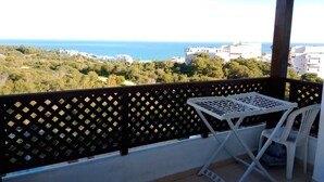Ein Balkon mit Blick auf das Meer und Gebäude.