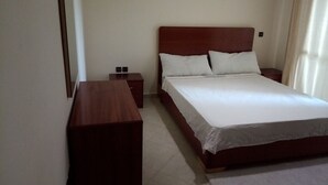 Ein Schlafzimmer mit einem hölzernen Bett, zwei Nachttischen und einem Beistelltisch.