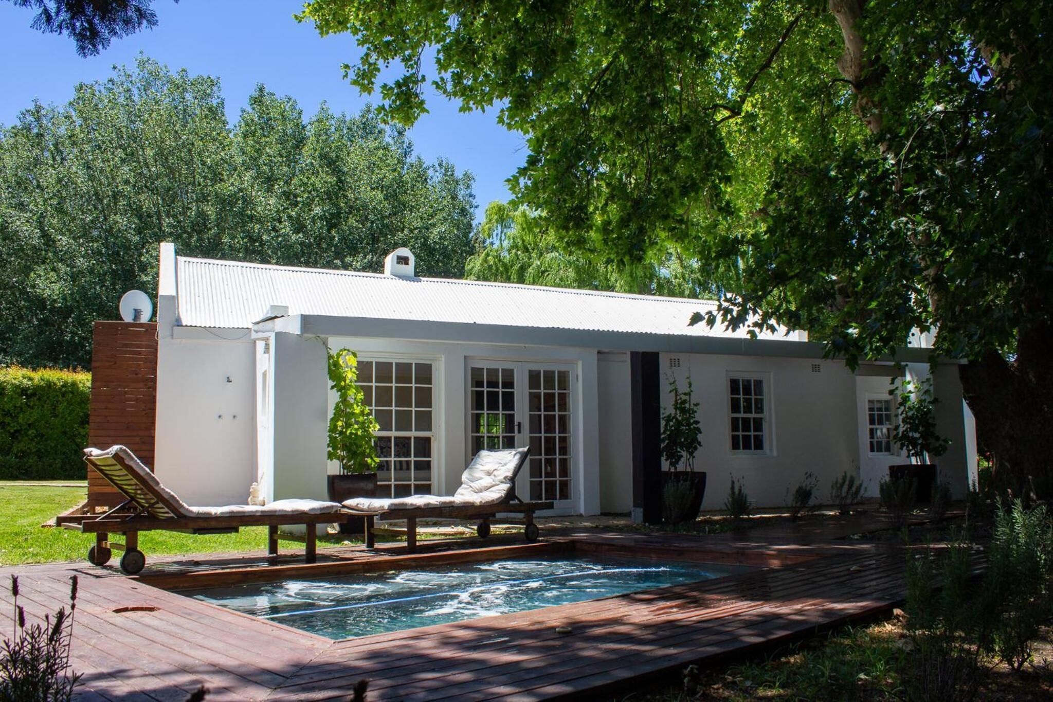 A modern house with a swimming pool, a deck, and a garden.