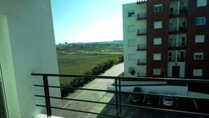 A balcony with a view of a parking lot and a multi-story building. - Ocean Atlantic Residence 3050 (Asilah)