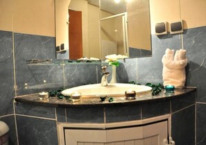 Une salle de bain avec un lavabo en marbre, un miroir et un porte-serviettes.
