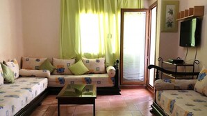 A cozy living room with a sofa set, a coffee table, and a television. - Residence Marina Beach Mdiq 3402 (Mdiq)