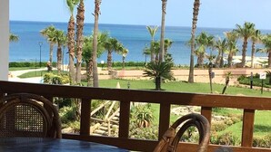 A balcony with a view of the ocean and palm trees. - Residence Marina Beach Mdiq 3402 (Mdiq)