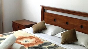 A neatly made bed with a floral bedspread, a wooden headboard, and two pillows. - Residence Marina Beach Mdiq 3402 (Mdiq)