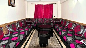 A dining area with a long table and multiple upholstered benches. - Residence Babylon Marrakech 3418 (Marrakech)