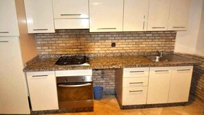 A kitchen with white cabinets, a granite countertop, a stainless steel sink, and a dishwasher. - Residence Babylon Marrakech 3418 (Marrakech)