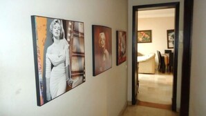 Un couloir orné de plusieurs œuvres d’art encadrées accrochées au mur.
