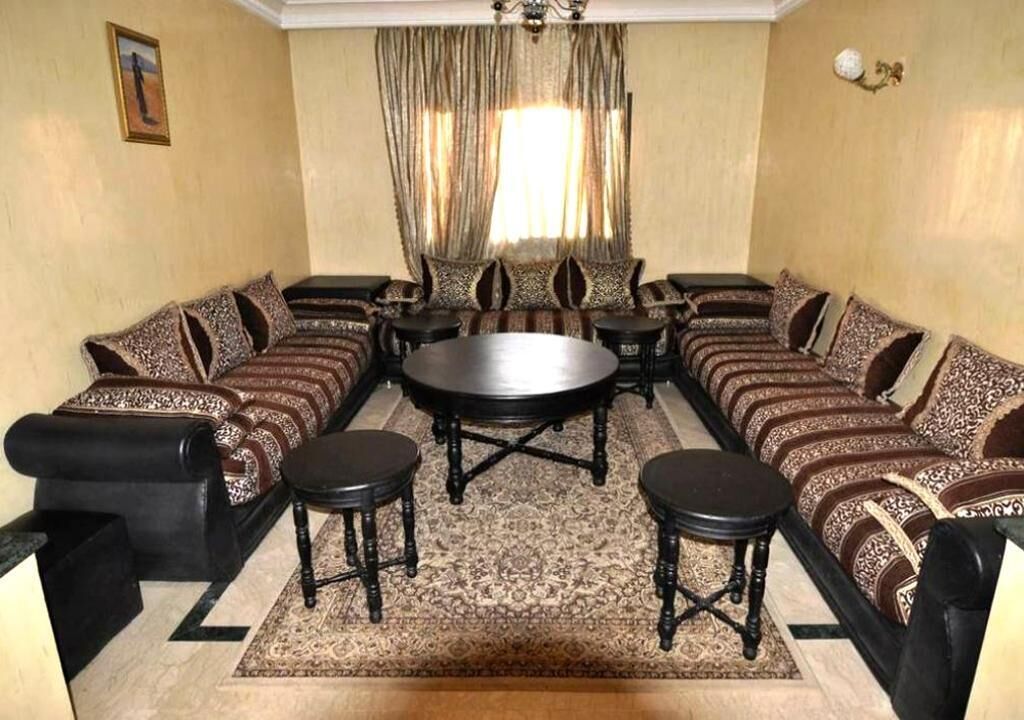 A living room with a sofa set, a round coffee table, and two side tables.