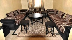 Ein Wohnzimmer mit einer Sofagarnitur, einem runden Couchtisch und zwei Beistelltischen.